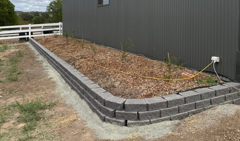 Long straight block garden edging along property fence line
